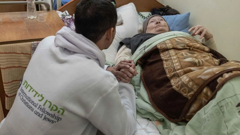 Voluntarios de la Fraternidad Internacional de Cristianos y Judíos ayudan a los ucranianos que estan en cama. 