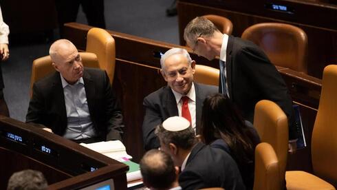 Benjamin Netanyahu estrecha la mano de Yariv Levin tras la votación.