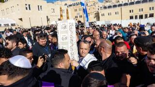 El legislador israelí Gilad Kariv sostiene un rollo de la Torá durante la sesión de oración de las Mujeres del Muro, en el Muro Occidental de la Ciudad Vieja de Jerusalem.