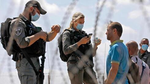 Agentes de la Policía de Fronteras comprueban la identidad de los palestinos.