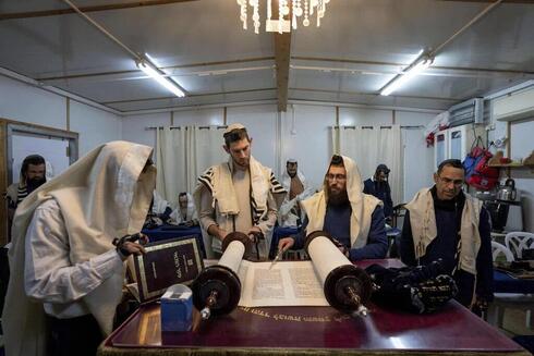 Colonos judíos participan en una oración matutina en su sinagoga en Beit Hogla. 