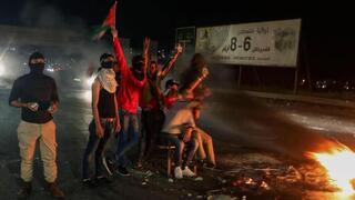 Palestinos protestan y queman neumáticos en el puesto de control de Huwara. 
