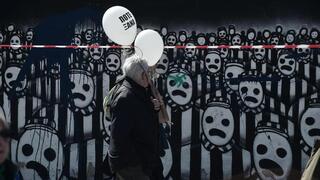 Los participantes sostienen globos con la leyenda "Nunca más" mientras caminan hacia la antigua estación de ferrocarril de Salónica.