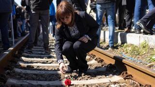 La Presidenta griega, Katerina Sakellaropoulou, deja un clavel en las vías del tren en Salónica.
