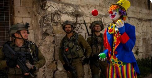 Un payaso camina frente a las tropas de defensa de Israel en Jerusalem.