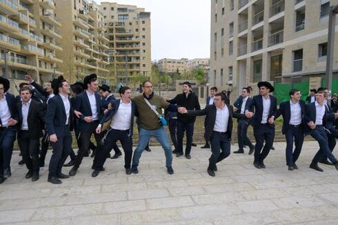 Amit Farber, organizador de la protesta, baila con jóvenes haredíes frente a la casa de Arye Deri en Jerusalem.