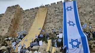 Manifestantes enrollan una copia gigante de la Declaración de Independencia en las murallas de la Ciudad Vieja de Jerusalem el jueves.