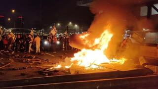 Manifestantes encienden hogueras en la autopista Ayalon, una de las principales vías de Tel Aviv, tras el despido del ministro de Defensa Yoav Gallant.
