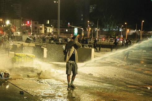 Un manifestante rociado con un cañón de agua en Tel Aviv. 