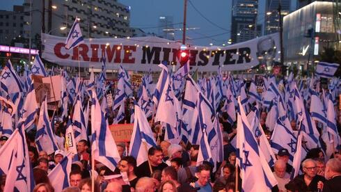 Miles de personas en la calle Kaplan, con el tradicional cartel anti Netanyahu de fondo. 