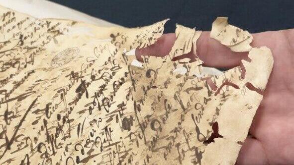 Un documento de la Inquisición perforado y devorado por la polilla. 