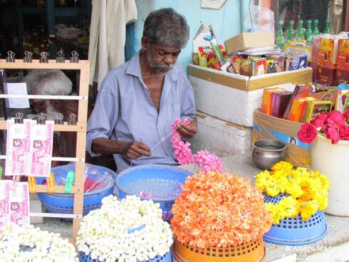 Artesano que prepara collares de flores para honrar a los dioses hindúes. 