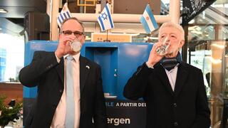 El embajador de Israel en Argentina, Eyal Sela, y el presidente de Buquebús, Juan Carlos López Mena, consumen un vaso de agua generada por Watergen. 