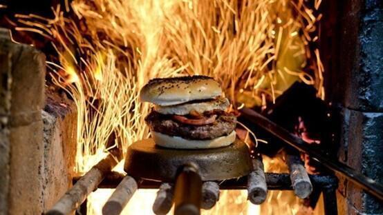 Una hamburguesa cocinada a fuego abierto. 