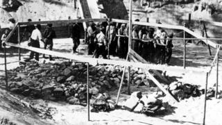 Judíos con la cabeza cubierta llevados al lugar del asesinato en Ponary por miembros de la milicia lituana, 1941.