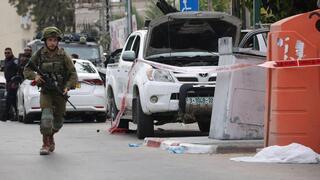 Un combatiente corre junto a una furgoneta utilizada por terroristas en Sderot. 