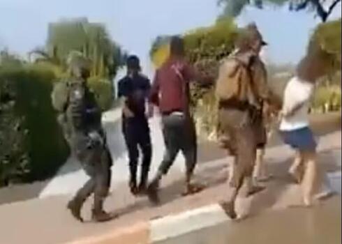 Militantes de Hamás trasladan a rehenes israelíes por una calle en Be'eri, un kibutz en el sur de Israel, según muestra un video publicado en X