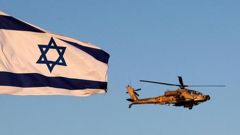 Un helicóptero de la Fuerza Aérea vuela sobre una bandera israelí.