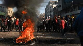 Turba enfurecida quemando neumáticos en Rafah, Gaza, en protesta por la subida de los precios de los alimentos.