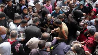 Habitantes del norte de Gaza se arremolinan ante un lugar de entrega de comida. 