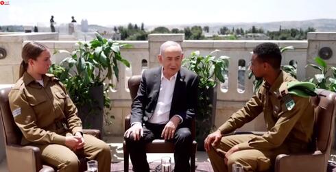 Netanyahu, con dos soldados, en uno de los videos que envió para no participar personalmente de los eventos del Día de la Independencia. 